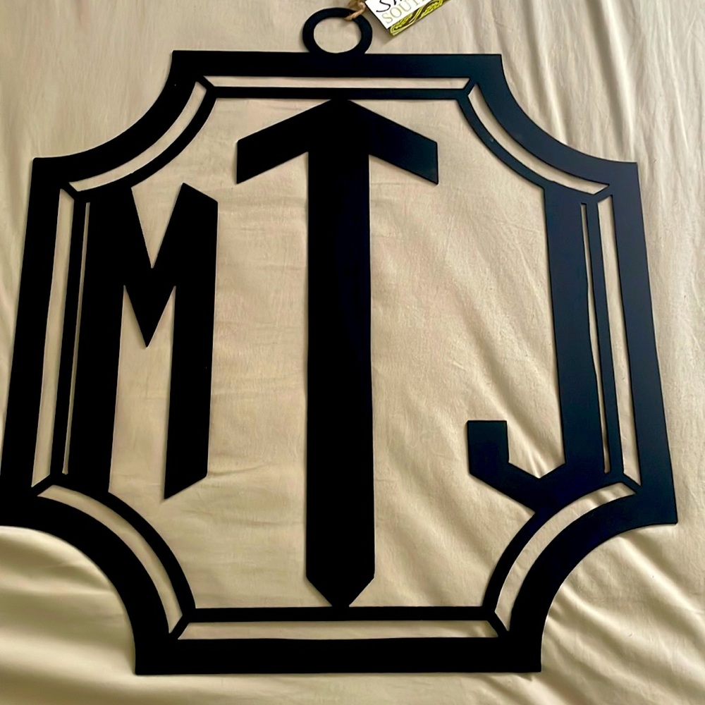 20” Monogramed Crest with Initials MJT. Black. Made of steel.